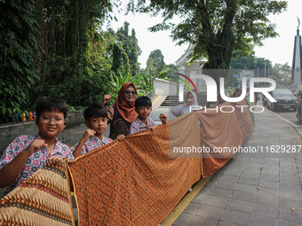 Several students and Bogor residents spread a 4-kilometer-long batik cloth along the pedestrian path, on October 2, 2024. UNESCO designated...