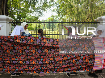 Several students and Bogor residents spread a 4-kilometer-long batik cloth along the pedestrian path, on October 2, 2024. UNESCO designated...