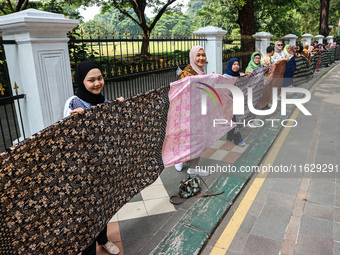 Several students and Bogor residents spread a 4-kilometer-long batik cloth along the pedestrian path, on October 2, 2024. UNESCO designated...