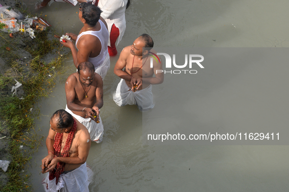 Hindu devotees perform the 'Tarpan' ritual to pay obeisance to their forefathers on the last day of 'Pitru Paksha' on the banks of the Mahan...