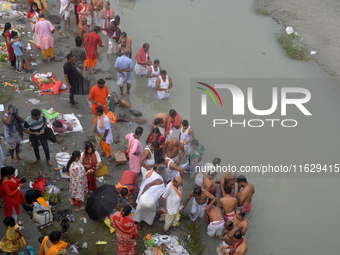 Hindu devotees perform the 'Tarpan' ritual to pay obeisance to their forefathers on the last day of 'Pitru Paksha' on the banks of the Mahan...