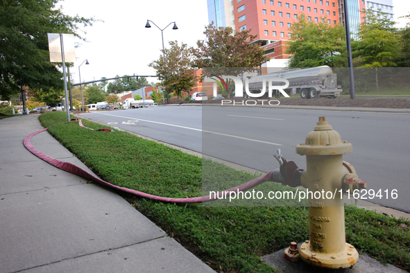 A fire hydrant is connected to a hose near Mission Hospital in Asheville, North Carolina on October 1, 2024. 