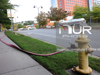 A fire hydrant is connected to a hose near Mission Hospital in Asheville, North Carolina on October 1, 2024. (