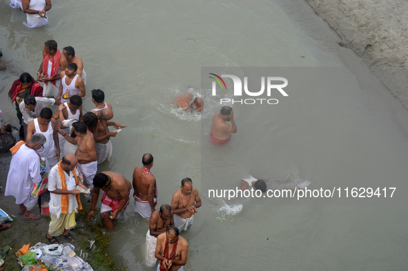 Hindu devotees perform the 'Tarpan' ritual to pay obeisance to their forefathers on the last day of 'Pitru Paksha' on the banks of the Mahan...