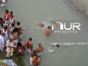 Hindu devotees perform the 'Tarpan' ritual to pay obeisance to their forefathers on the last day of 'Pitru Paksha' on the banks of the Mahan...