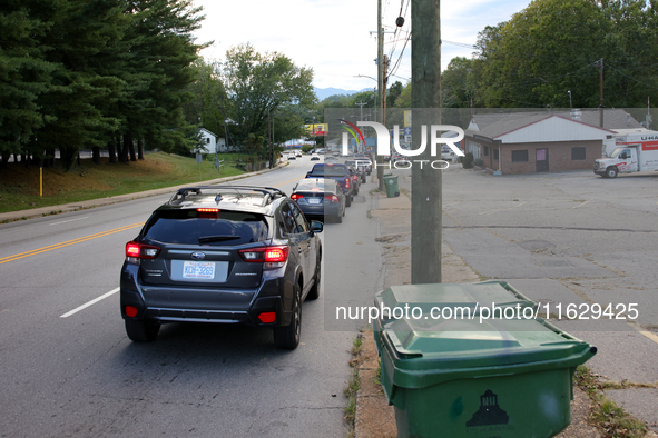 Vehicles wait in line for gasoline in Asheville, North Carolina on October 1, 2024 after Hurricane Helene caused widespread damage, cutting...