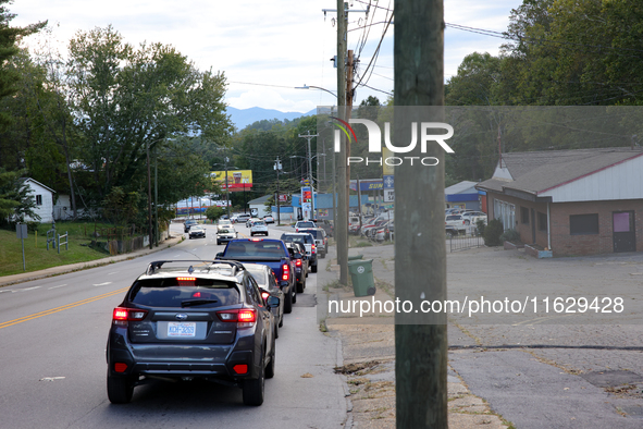 Vehicles wait in line for gasoline in Asheville, North Carolina on October 1, 2024 after Hurricane Helene caused widespread damage, cutting...