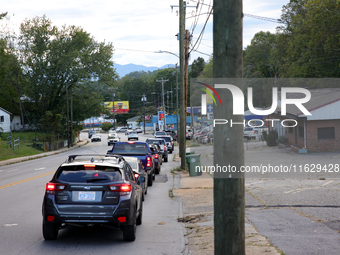 Vehicles wait in line for gasoline in Asheville, North Carolina on October 1, 2024 after Hurricane Helene caused widespread damage, cutting...