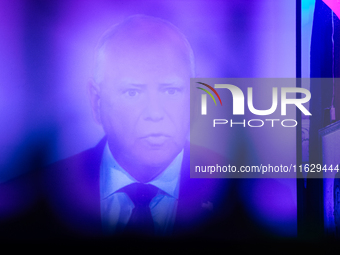 Minnesota Gov. Time Walz (D) appears on a large screen during the vice presidential debate, under the pink and purple lights at Madhatter in...