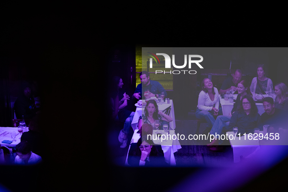 People react to the vice presidential debate during a watch party at under the pink and purple lights at Madhatter in Washington, DC, on Oct...