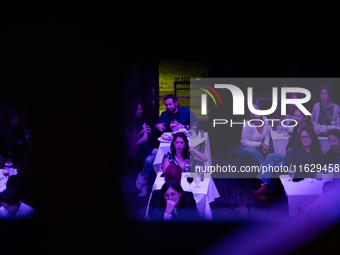 People react to the vice presidential debate during a watch party at under the pink and purple lights at Madhatter in Washington, DC, on Oct...