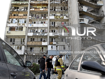 Men walk past the residential building damaged by Russian shelling in Zaporizhzhia, Ukraine, on October 1, 2024. NO USE RUSSIA. NO USE BELAR...