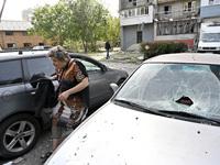 A woman stands next to cars damaged by Russian shelling in Zaporizhzhia, Ukraine, on October 1, 2024. NO USE RUSSIA. NO USE BELARUS. (