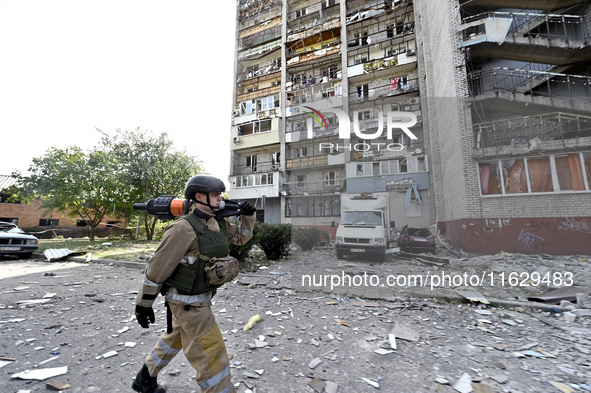 A rescuer passes by the residential high-rise damaged by Russian shelling in Zaporizhzhia, Ukraine, on October 1, 2024. NO USE RUSSIA. NO US...