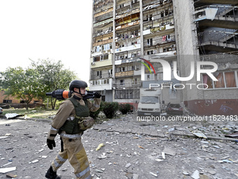 A rescuer passes by the residential high-rise damaged by Russian shelling in Zaporizhzhia, Ukraine, on October 1, 2024. NO USE RUSSIA. NO US...