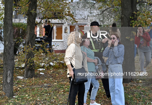 A police officer stands next to women who suffer from Russian shelling in Zaporizhzhia, Ukraine, on October 1, 2024. 