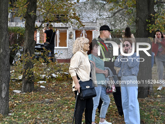 A police officer stands next to women who suffer from Russian shelling in Zaporizhzhia, Ukraine, on October 1, 2024. (