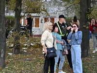 A police officer stands next to women who suffer from Russian shelling in Zaporizhzhia, Ukraine, on October 1, 2024. (