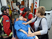 Medical workers and a policeman carry a 90-year-old local resident, Valentyna, on a stretcher after she sustains injuries as a result of Rus...