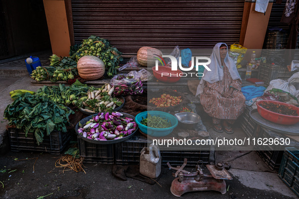 An elderly woman sells vegetables and waits for customers on a roadside in Baramulla, Jammu and Kashmir, India, on October 2, 2024. 