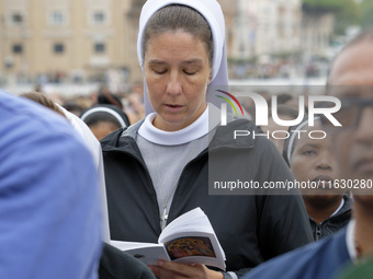 A nun attends The Holy Mass led by Pope Francis for the opening session of the 16th Ordinary General Assembly of the Synod of Bishops in Vat...