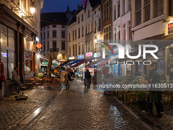 People walk on a street next to the Grand Place in Brussels, Belgium, on September 27, 2024. (