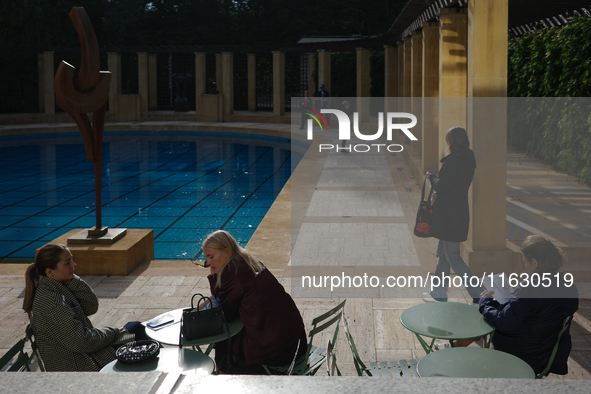 People sit at tables outside the Maison Empain in Brussels, Belgium, on September 29, 2024. 