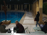 People sit at tables outside the Maison Empain in Brussels, Belgium, on September 29, 2024. (