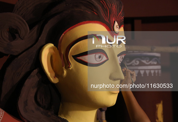 An artisan, Upshona Chatterjee, prepares idols of the Hindu goddess Durga during the auspicious day of Mahalay in a ''pandal'' or temporary...