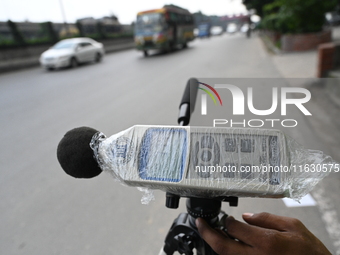 A volunteer checks the sound level meter on the street to measure noise levels during the No Horn campaign at Airport Road in Dhaka, Banglad...