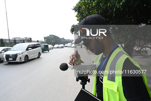 A volunteer checks the sound level meter on the street to measure noise levels during the No Horn campaign at Airport Road in Dhaka, Banglad...