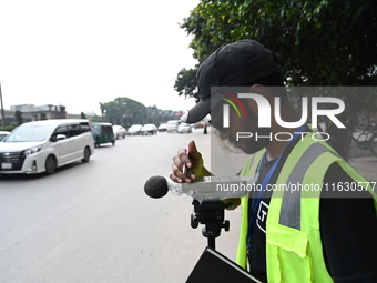 A volunteer checks the sound level meter on the street to measure noise levels during the No Horn campaign at Airport Road in Dhaka, Banglad...