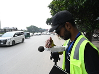 A volunteer checks the sound level meter on the street to measure noise levels during the No Horn campaign at Airport Road in Dhaka, Banglad...