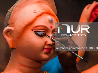 Artisans work on finishing touches of Goddess Durga idols at a workshop in the potter's colony of Tehatta, West Bengal, India, on October 2,...