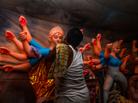 Artisans work on finishing touches of Goddess Durga idols at a workshop in the potter's colony of Tehatta, West Bengal, India, on October 2,...