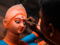 Artisans work on finishing touches of Goddess Durga idols at a workshop in the potter's colony of Tehatta, West Bengal, India, on October 2,...