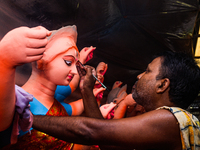 Artisans work on finishing touches of Goddess Durga idols at a workshop in the potter's colony of Tehatta, West Bengal, India, on October 2,...