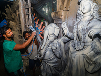 Artisans work on finishing touches of Goddess Durga idols at a workshop in the potter's colony of Tehatta, West Bengal, India, on October 2,...