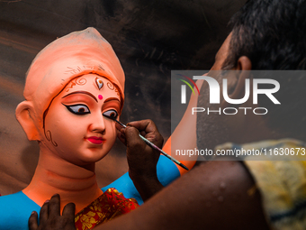 Artisans work on finishing touches of Goddess Durga idols at a workshop in the potter's colony of Tehatta, West Bengal, India, on October 2,...