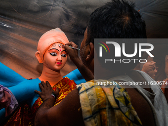 Artisans work on finishing touches of Goddess Durga idols at a workshop in the potter's colony of Tehatta, West Bengal, India, on October 2,...