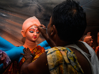 Artisans work on finishing touches of Goddess Durga idols at a workshop in the potter's colony of Tehatta, West Bengal, India, on October 2,...