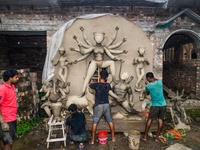 Artisans work on finishing touches of Goddess Durga idols at a workshop in the potter's colony of Tehatta, West Bengal, India, on October 2,...