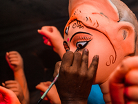 Artisans work on finishing touches of Goddess Durga idols at a workshop in the potter's colony of Tehatta, West Bengal, India, on October 2,...