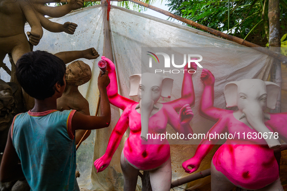 Artisans work on finishing touches of Goddess Durga idols at a workshop in the potter's colony of Tehatta, West Bengal, India, on October 2,...