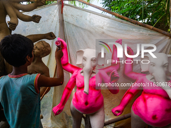 Artisans work on finishing touches of Goddess Durga idols at a workshop in the potter's colony of Tehatta, West Bengal, India, on October 2,...