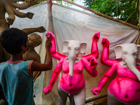 Artisans work on finishing touches of Goddess Durga idols at a workshop in the potter's colony of Tehatta, West Bengal, India, on October 2,...