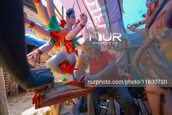 A local artist decorates the idol of Hindu Goddess Durga at his studio in Lalitpur, Nepal, on October 2, 2024. Nepal, along with India, cele...