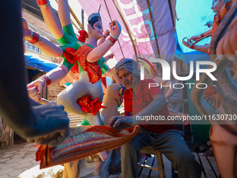 A local artist decorates the idol of Hindu Goddess Durga at his studio in Lalitpur, Nepal, on October 2, 2024. Nepal, along with India, cele...