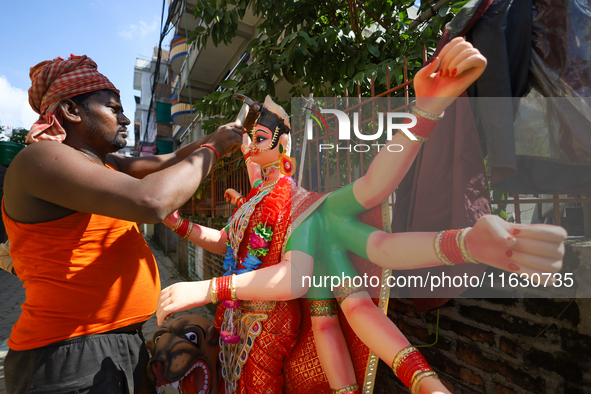 A local artist decorates the idol of Hindu Goddess Durga at his studio in Lalitpur, Nepal, on October 2, 2024. Nepal, along with India, cele...