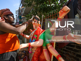 A local artist decorates the idol of Hindu Goddess Durga at his studio in Lalitpur, Nepal, on October 2, 2024. Nepal, along with India, cele...